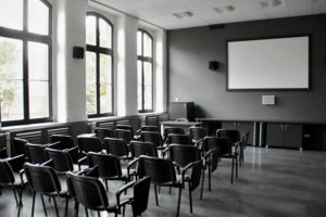 wnętrze sali multimedialnej, ekran na scianie i krzesła