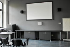wnętrze sali multimedialnej, ekran na scianie i szafki