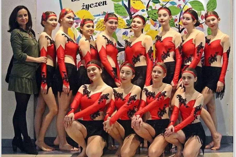 grupa tancerek w czerwonych strojach z nauczycielką