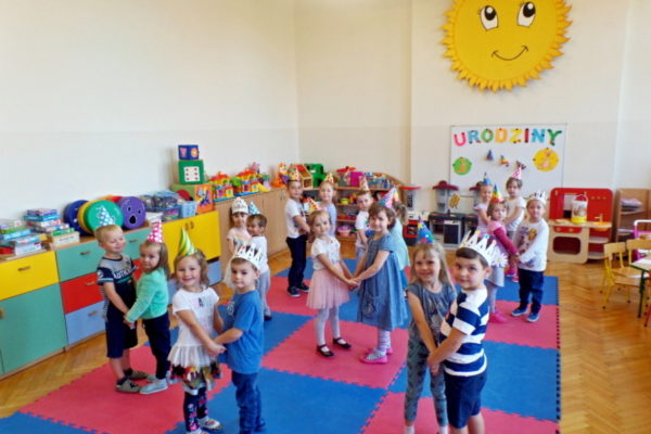 Tańczące dzieci trzymają się za ręce