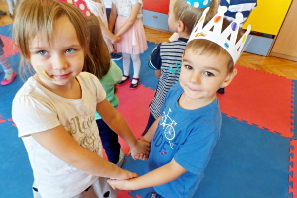 Dziewczynka tańczy z chłopcem w koronie