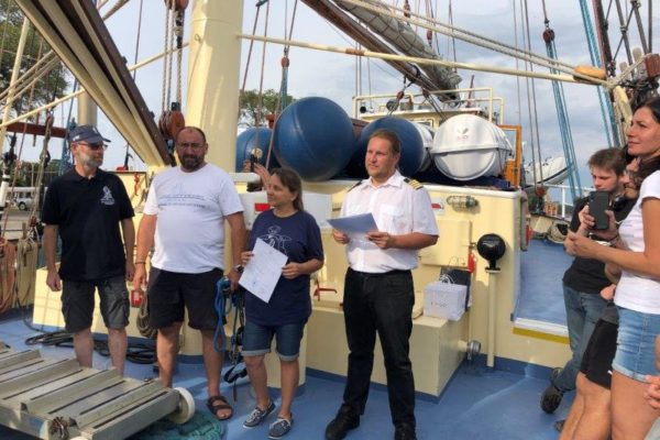 Na pokładzie Kapitan, Bożenka trzyma w ręku opinię z rejsu obok stoi Bosman i nasz Jurek