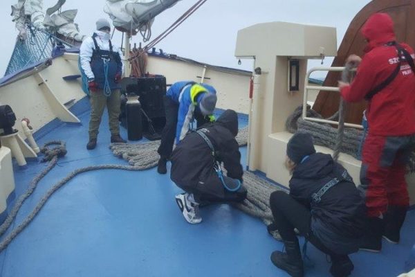 5 członków I wachty na dziobie klaruje cumy na pokładzie oraz zdejmuje je ze stojaka