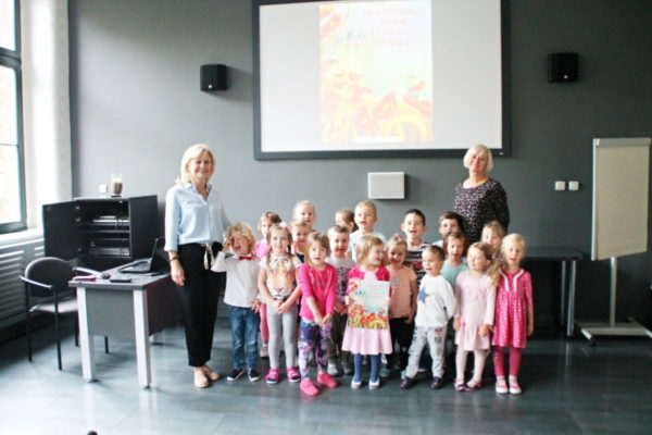 Zdjęcie grupowe - dzieci wraz z nauczycielkami na tle ekranu