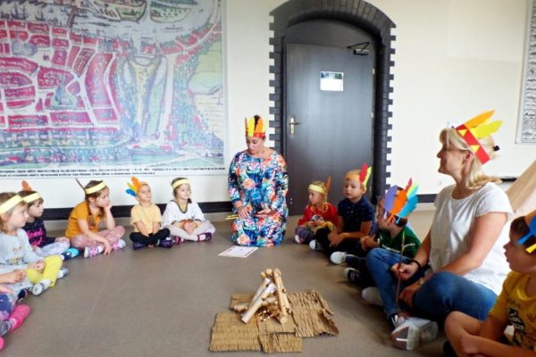 przedszkolaki siedzą wokół sztucznego ogniska, nauczycielka czyta list od Wodza