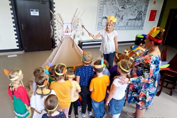 grupa przedszkolaków z nauczycielkami, stoją przy tipi - indiańskim namiocie