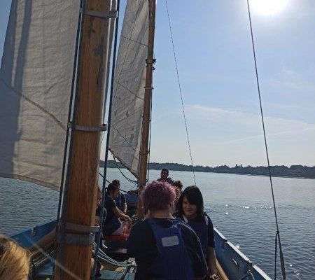 6 uczniów Szkolnego Koła Edukacji Morskiej z Technikum Ekonomicznego siedzących pod żaglami na Dezecie