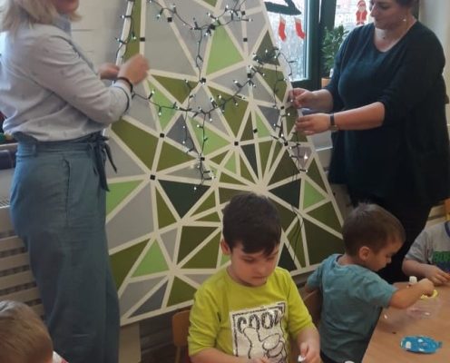 Panie stroją choinkę lampakami