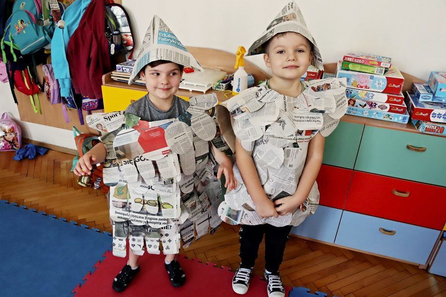 dwoje dzieci w strojach zrobionych z gazety