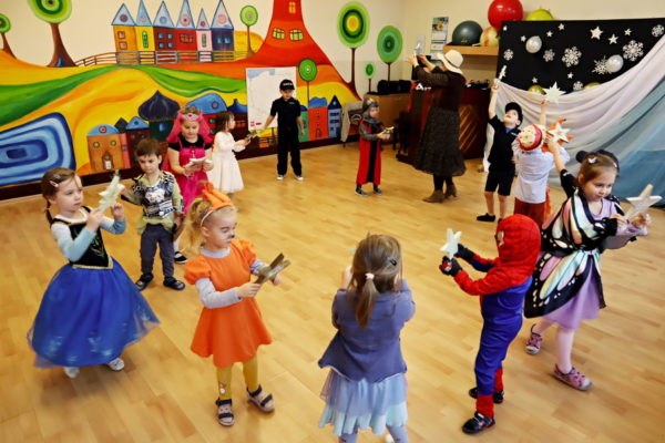 grupa przedszkolaków strojach karnawałowych tańczących w kole