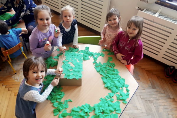 grupa przedszkolaków przy stole, podczas prac plastcznej