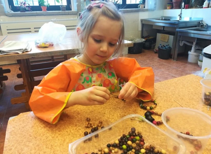 dziewczynka nawlekajaca koraliki