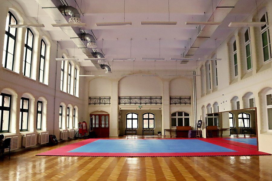 wnętrze salu gimnastycznej w Pałacu Młodzieży, na środku duż mata niebiesko-czerwona