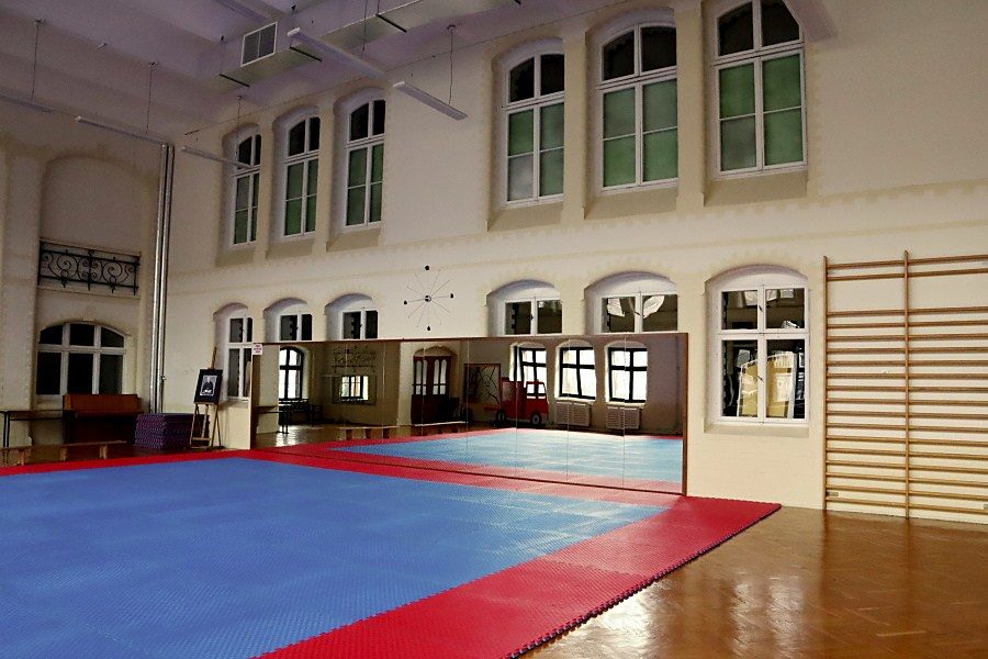 wnętrze salu gimnastycznej w Pałacu Młodzieży, na środku duż mata niebiesko-czerwona