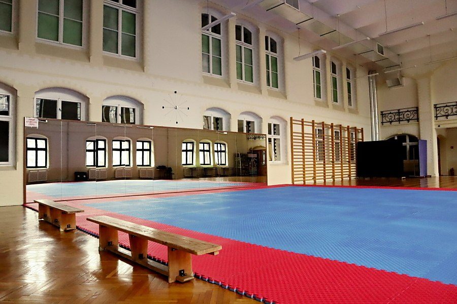 wnętrze salu gimnastycznej w Pałacu Młodzieży, na środku duż mata niebiesko-czerwona