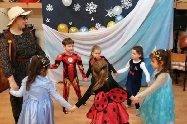 grupa dzieci w strojach karnawałowych podczas zabawy w kole