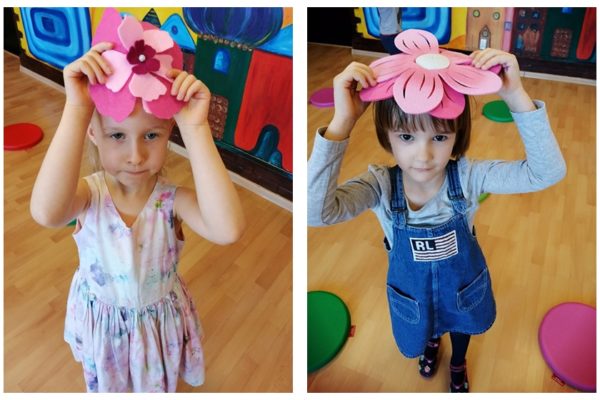 dwie dziewczynki trzmające na głowach kwiatki