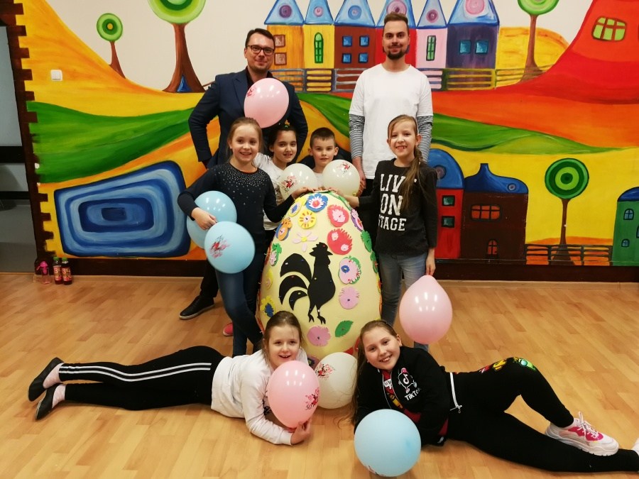 grupa dzieci pozuje z nauczycielami przy wielkiej pisance