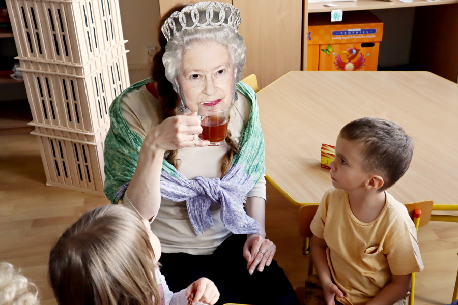 kobieta z maską królowej Elżbiety na twarzy