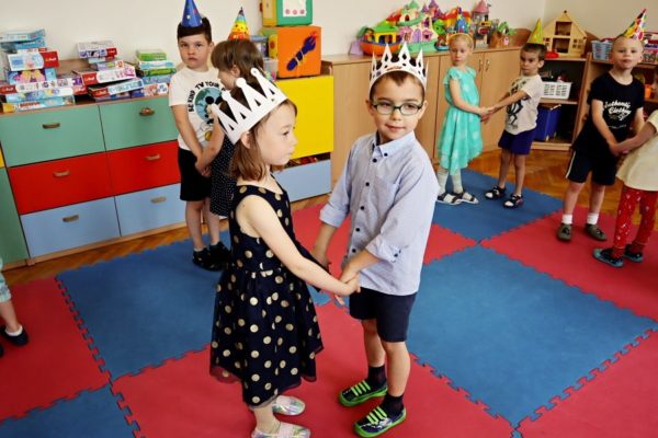 chłopiec z dziewczynką tańczą w parze, w tle inne dzieci