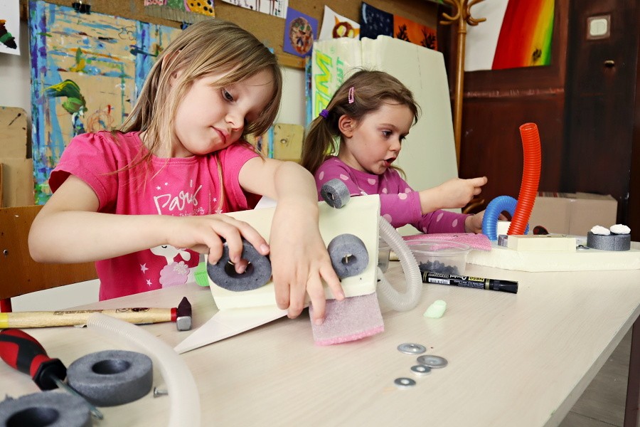 dwie dziewczynki siedzące przy stole podczas konstruouwania