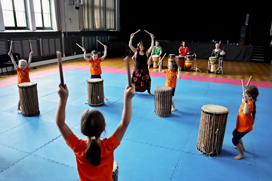 dziewczęta grające na bębnach z nauczycielką