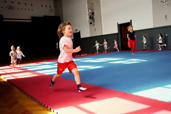 zajęcia na sali gimnstycznej, biegnąca dziewczynka