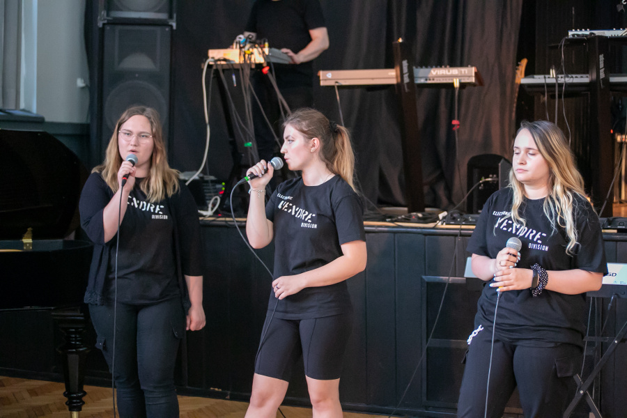 trzy wokalistki z mikrofonami