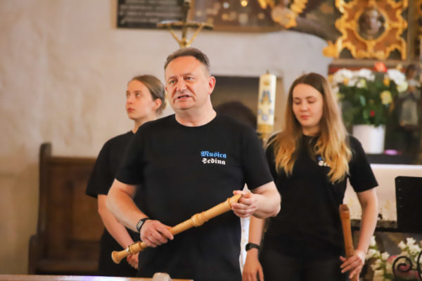 trzy osoby, z przodu mężczyzna trzymający flet