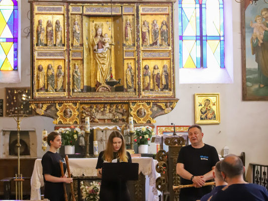 wnętrze kościoła i trzy osoby grafjące na instrumentach