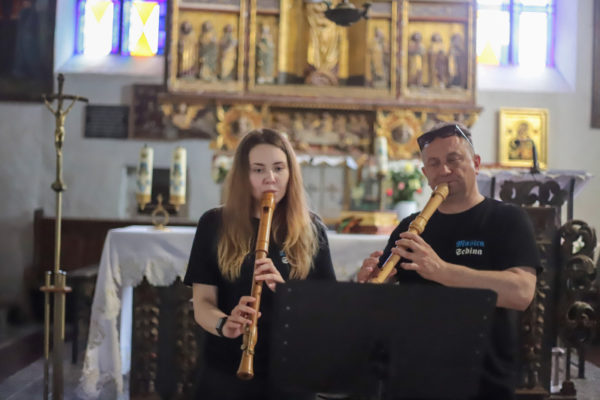 dwie osoby grafjące na fletach w kościele