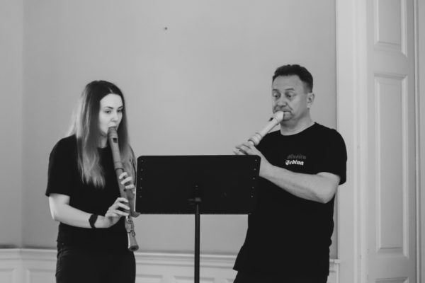 dwie osoby grające na fletach