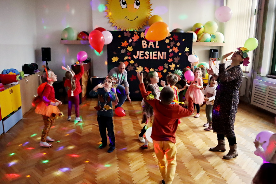 grupa dzieci podczas zabawy w sali w tle tablica z napisem bal jesieni