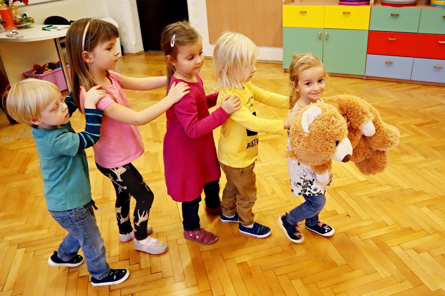 grupa dzieci trzymających się za ramiona