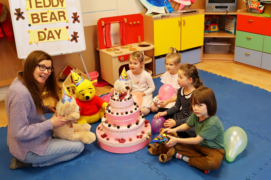 grupa dzieci z nauczycielką siedzi przy torcie