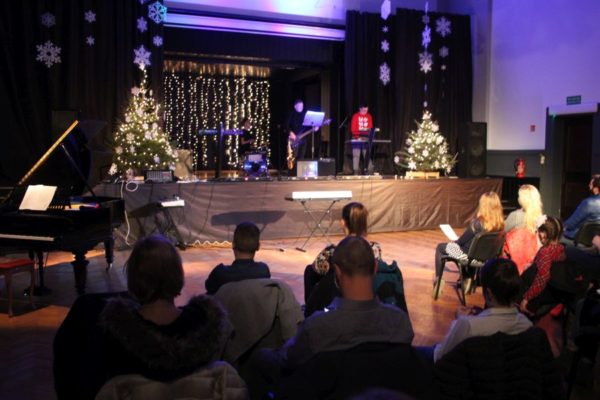 zespół muzyczny na scenie na pierwszym planie publika