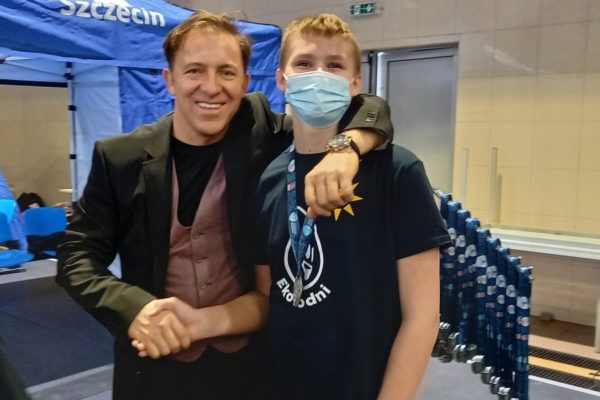 mężczyzna ściska dłoń chłopcu w maseczce