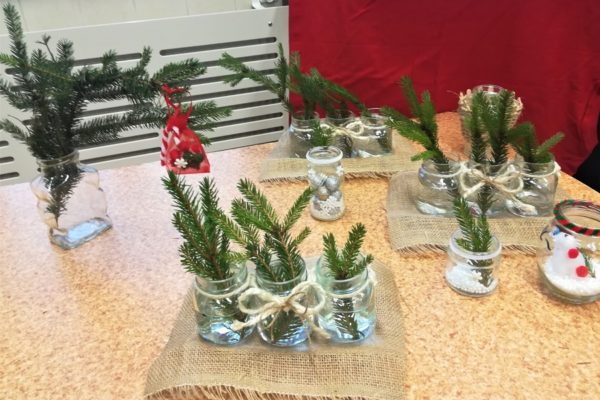 Słoikowe ozdoby stojące na stole.