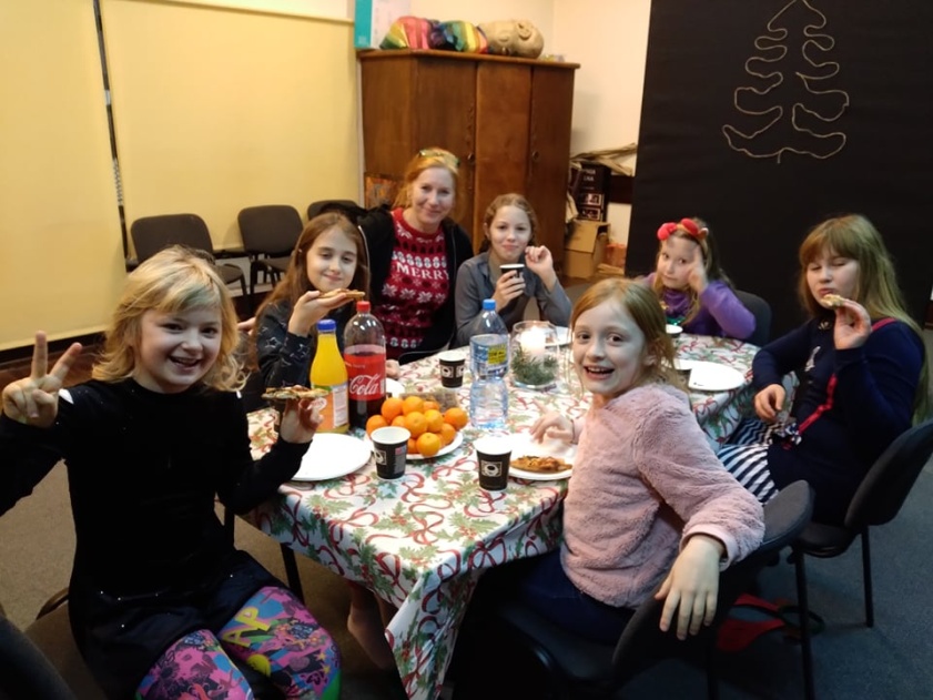 grupa dzieci przy stole, pozuje do zdjecia z nauczycielką