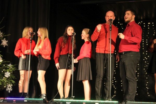 grupa młodzieży na scenie w czerwonych bluzkach