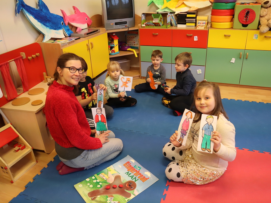 grupa dzieci siedzi na macie z nauczycielką