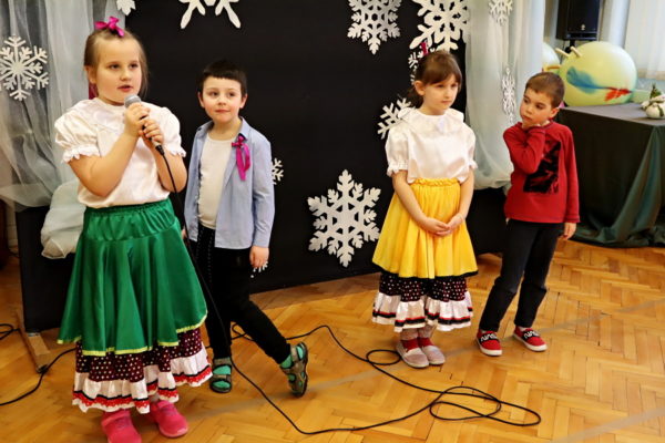 grupa dzieci, dziewczynka z mikrofonem śpiewa