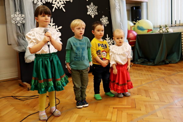 grupa dzieci, dziewczynka z mikrofonem śpiewa