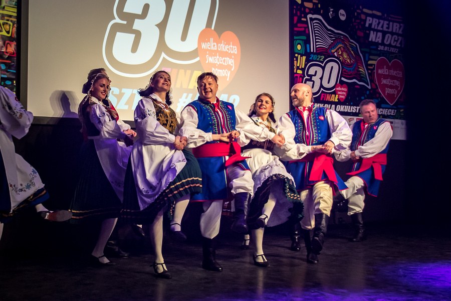 grupa osób w tańczących w strojach ludowych