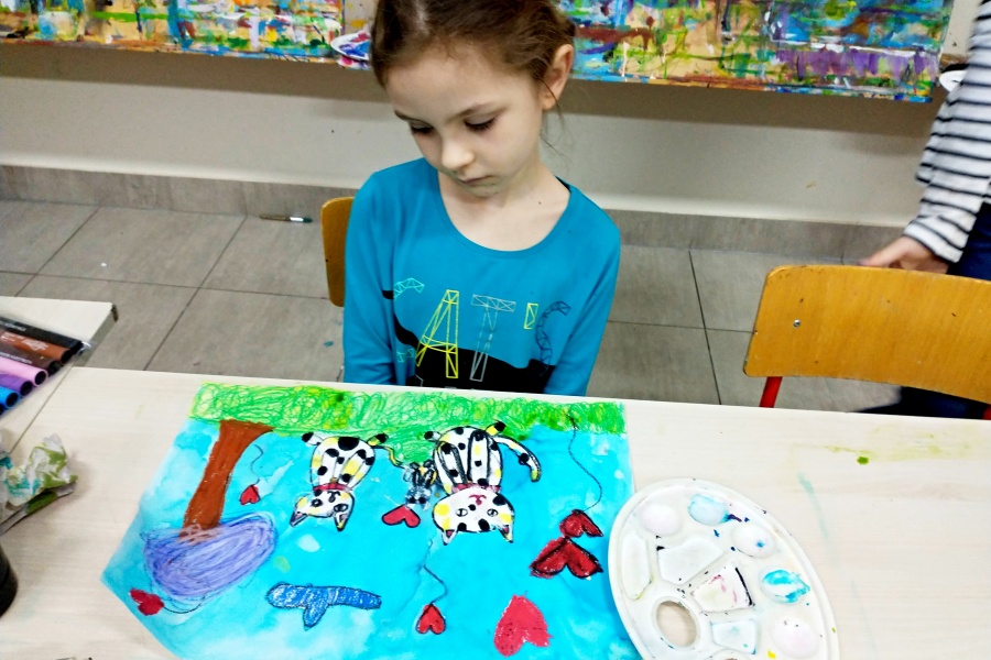 dziewczynka siedząca przy swojej pracy plastycznej