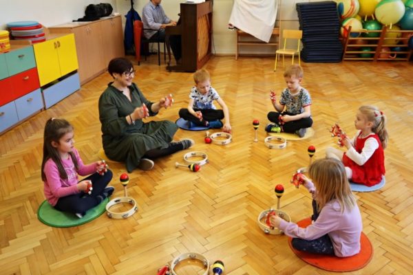 grupa dzieci z nauczycielką w trakcie zabawy