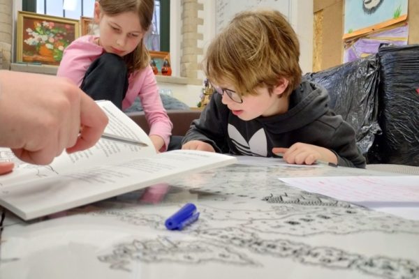 uczestnicy pochyleni nad rysunkiem