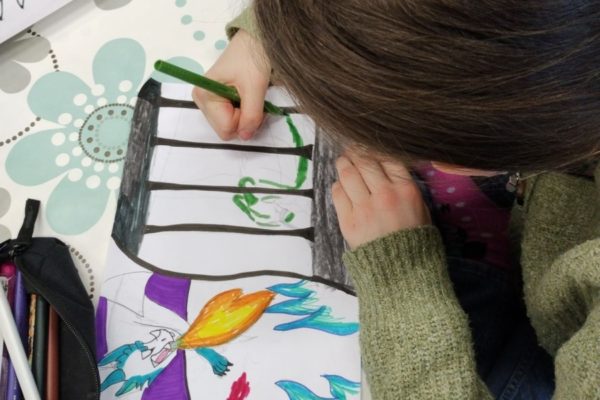 osoba pochylona nad rysunkiem