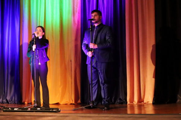 dwoje młodych ludzi stojacyh na scenie