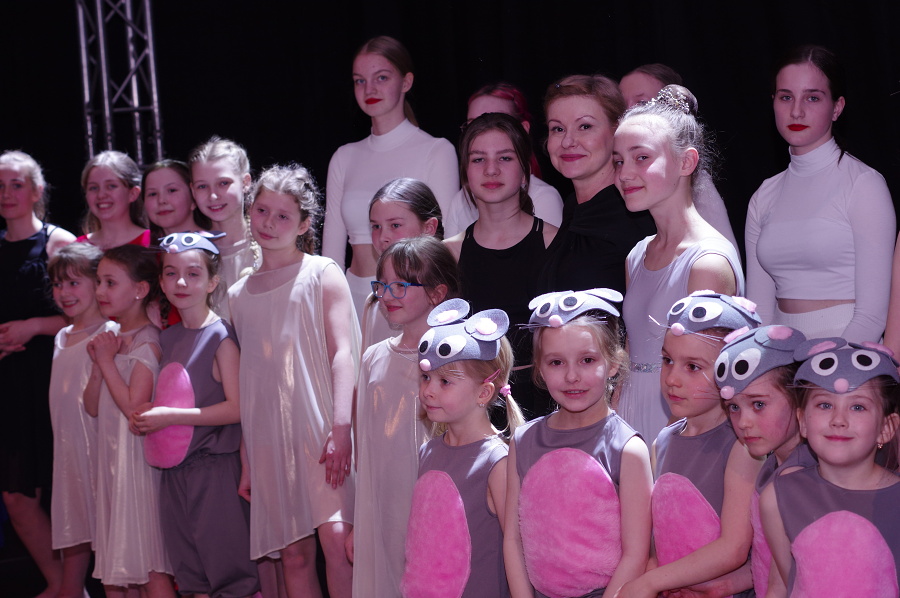 grupa tancerek na scenie z opiekunem art.